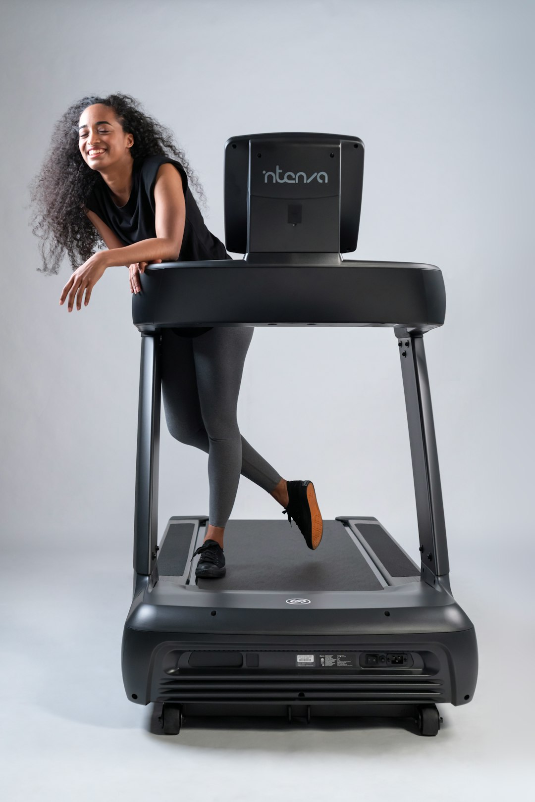 portfolio-05 Happy, fit young woman pauses from her workout on an Intenza 450 Series Treadmill to share a smile.